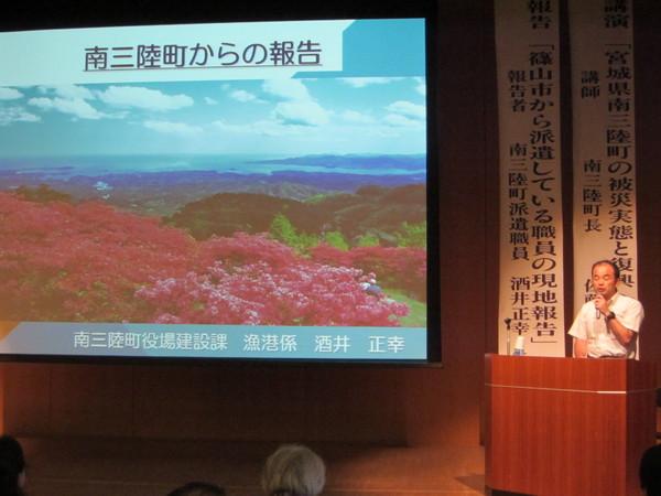 南三陸町からの報告の映像を見ながら篠山市職員 酒井 正幸君が現地報告をしている写真